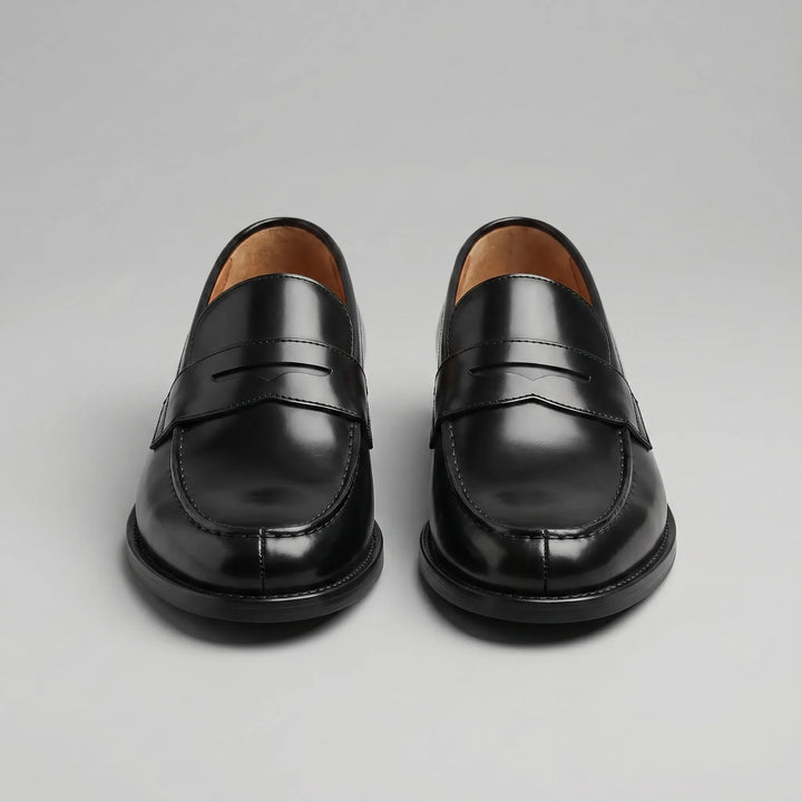 Stijlvolle zwarte slip-on penny loafers voor heren, een klassiek model met ronde neus en tijdloze uitstraling.