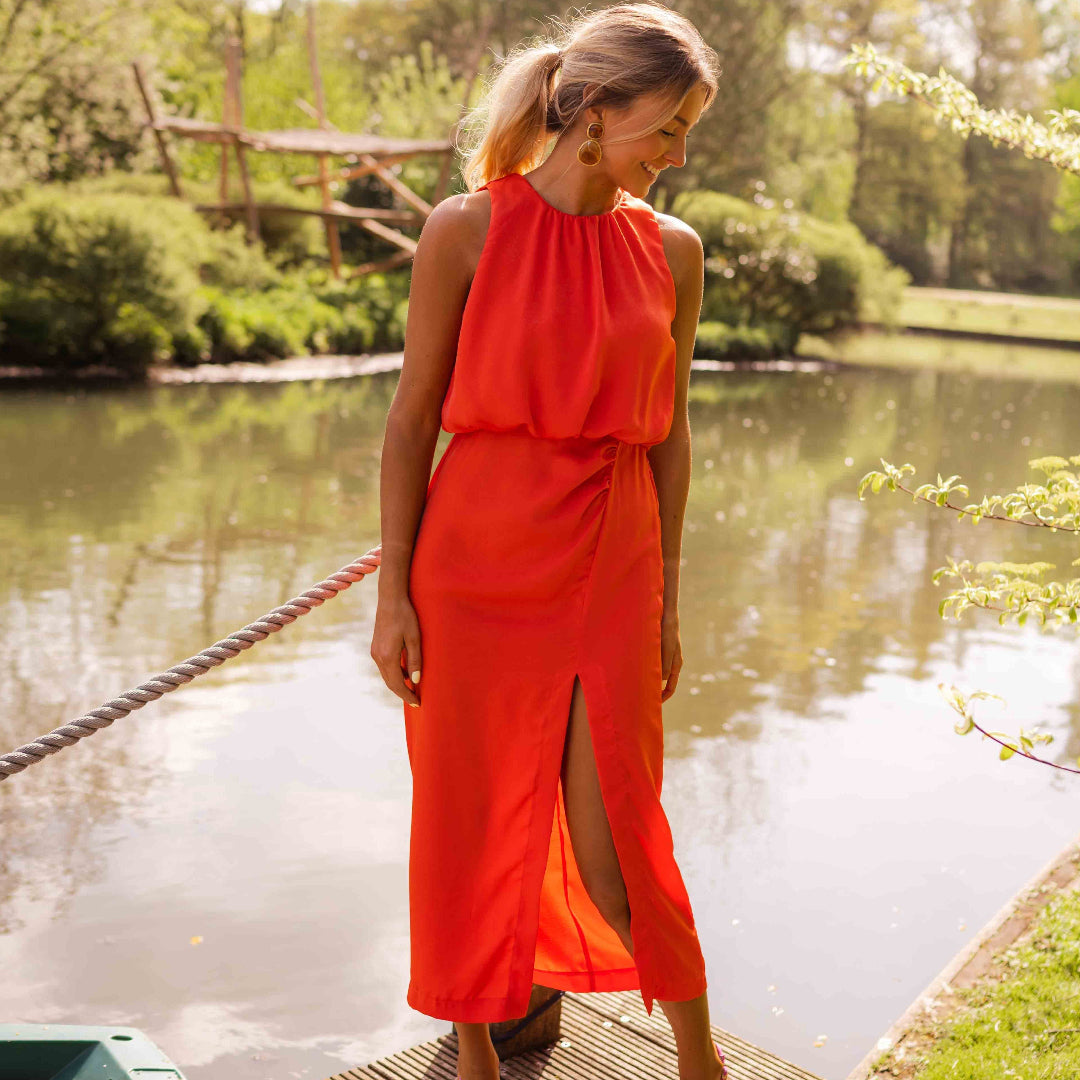 Stijlvolle dames midi jurk in rood met hoge halslijn, mouwloos design en split, geschikt voor feestjes.