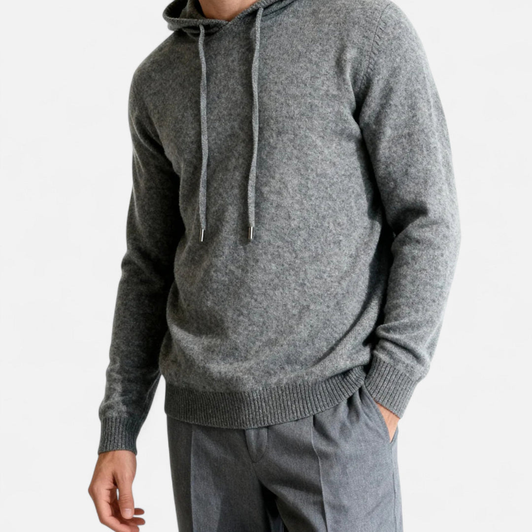 Man draagt stijlvolle heren Leo hoodie, minimalistische luxe trui met capuchon voor casual herfst/winter look.