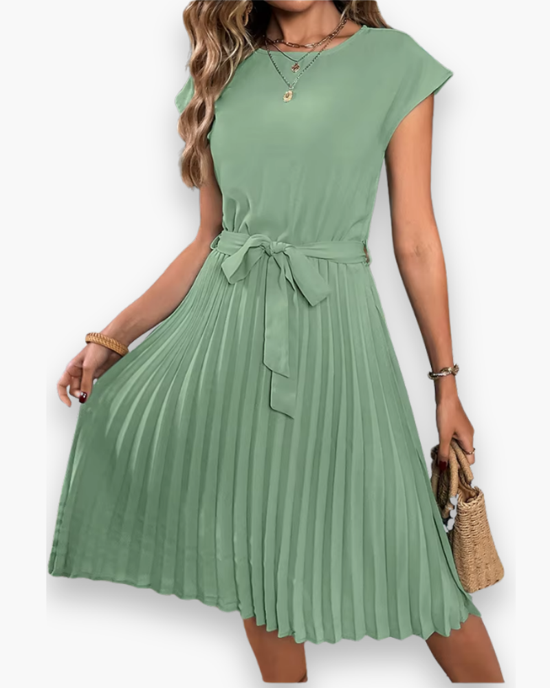 Vrouw draagt een elegante, geplooide midi jurk, perfect voor zowel casual als feestelijke momenten.