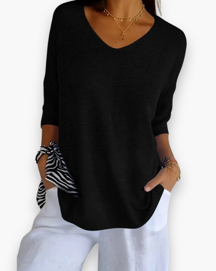Comfortabele dames zomertop met V-hals en ruime pasvorm, essentieel voor een luchtige zomerse outfit.