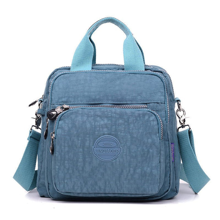 Compacte waterdichte rugzak voor dames, omvormbaar tot schoudertas of handtas.