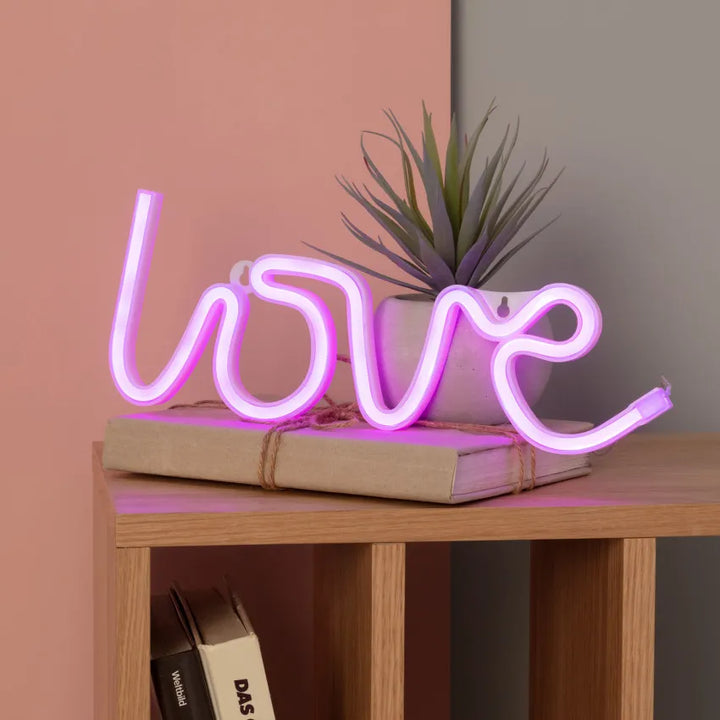 Romantische 'Love' neonletters als sfeerlicht in een moderne slaapkamer, creëert een warme ambiance.