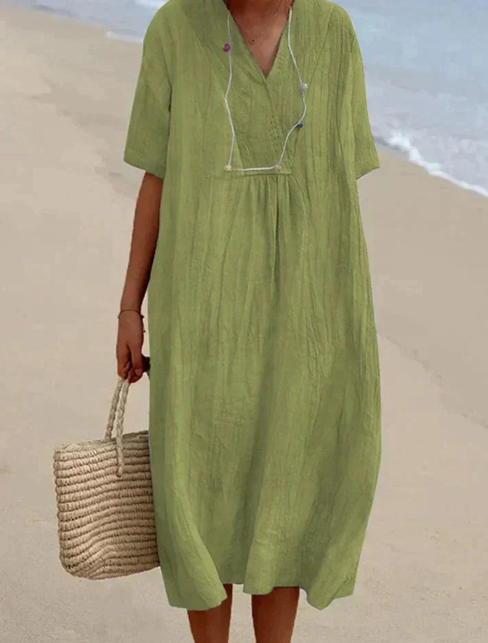 Comfortabele midi strandjurk Aria van katoen linnen, perfect voor de zomer met handige zakken.