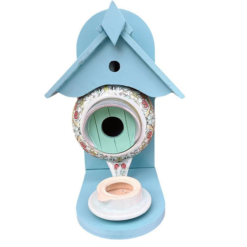 Sfeervol theepot vogelvoederhuisje. Tuindecoratie van keramiek en hars trekt vogels aan. Perfect cadeau.