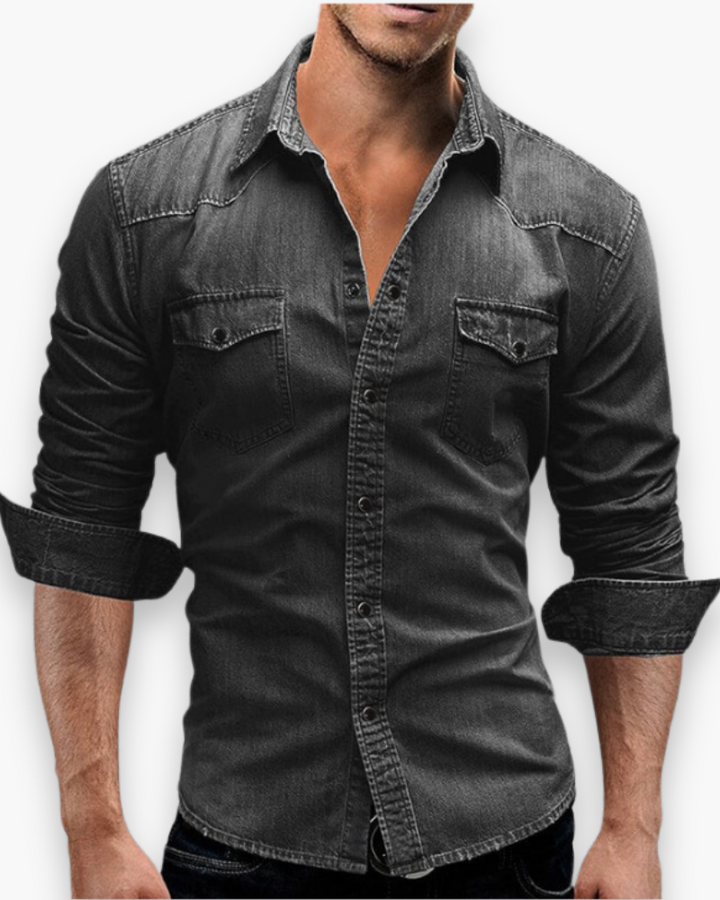 Openhangend heren spijkeroverhemd over een wit T-shirt, creëert een relaxte, gelaagde look.