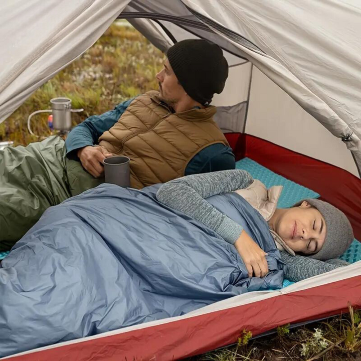 Ademende lichtgewicht slaapzak met isolatie voor comfortabel kamperen en outdoor avonturen. Groen en compact.