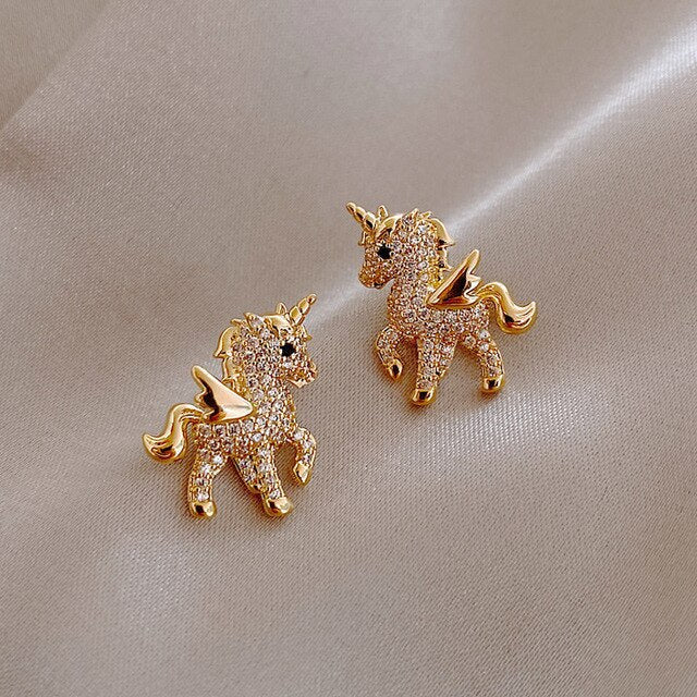 Elegante goudkleurige eenhoorn oorbellen voor dames, versierd met sprankelende zirkonia stenen. Fantasie sieraden.