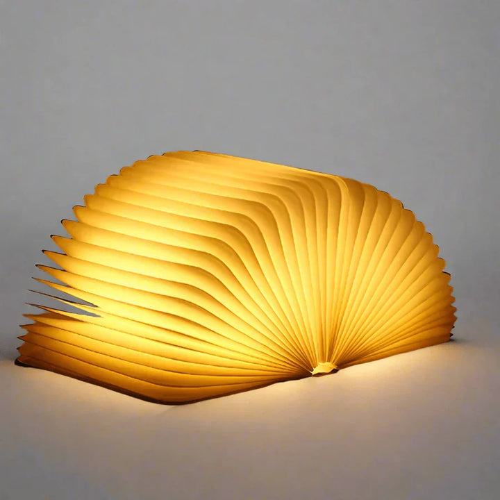 Volledig geopende StoryGlow boekenlamp, verspreidt warm LED licht, functioneel en sfeervol.