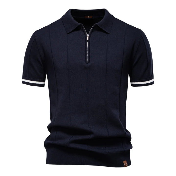 Detailopname van de ritssluiting op een stijlvolle heren polo met opvallende verticale lijnen.