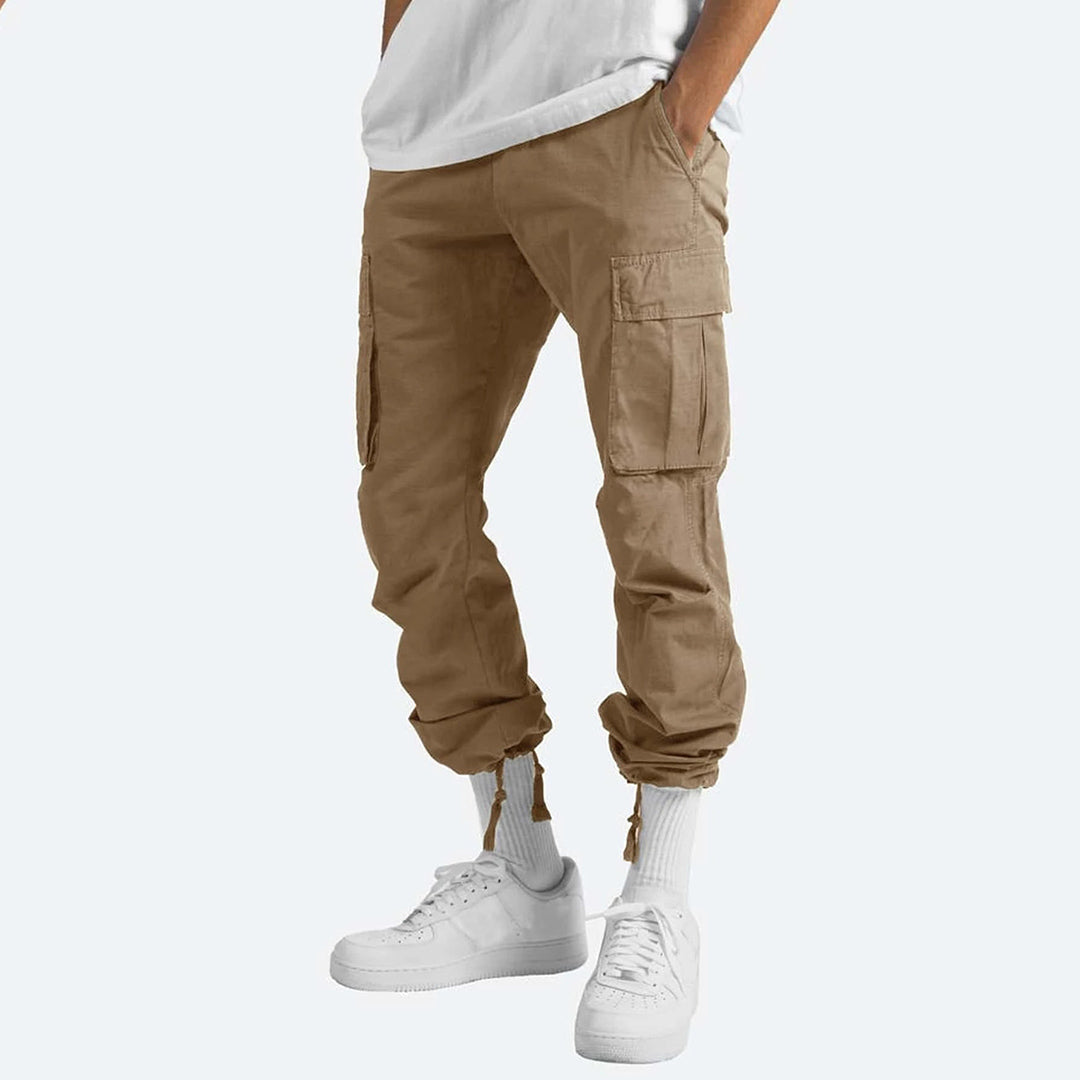 Model draagt comfortabele heren cargo zomerbroek in een ontspannen zomerse setting.