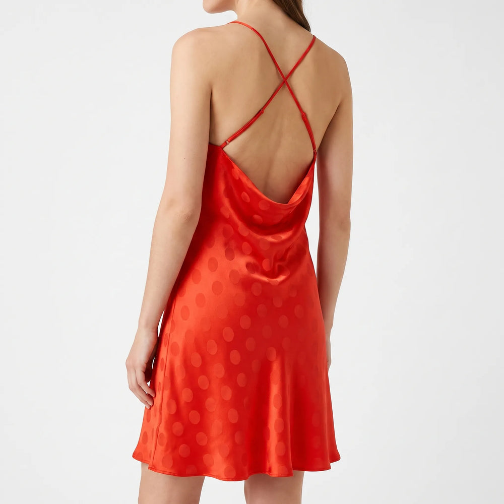 Modieuze rode dames jurk met speels stippenpatroon, diepe open rug en delicate spaghetti bandjes, perfect als feestjurk.