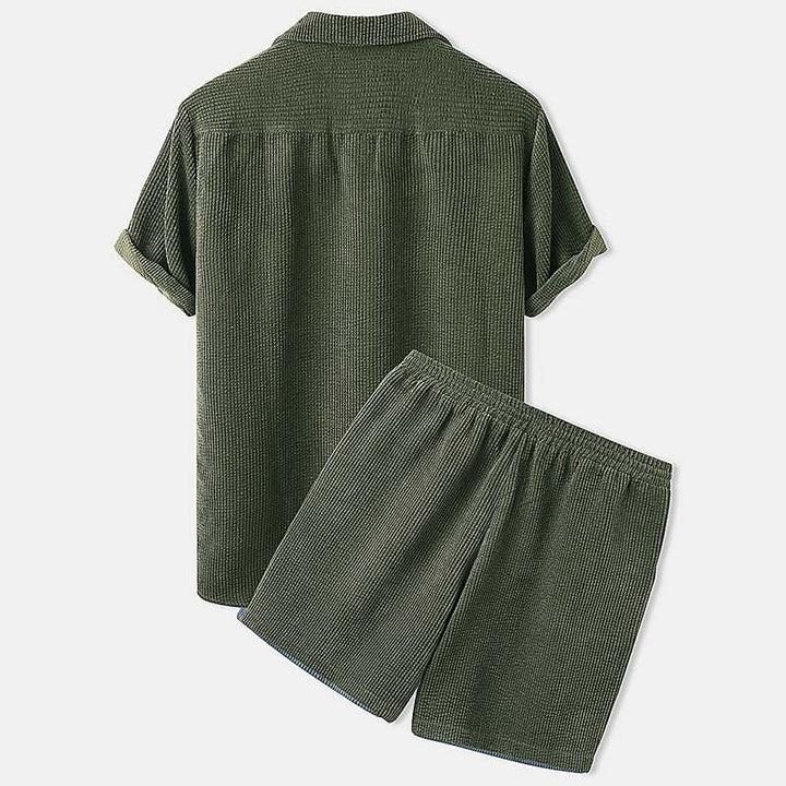 Model draagt heren casual zomer combiset, een comfortabele en stijlvolle 2-delige outfit voor ontspannen momenten.