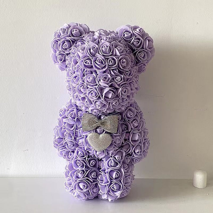 Detailopname: textuur van kunstbloemrozen op een decoratieve teddybeer.