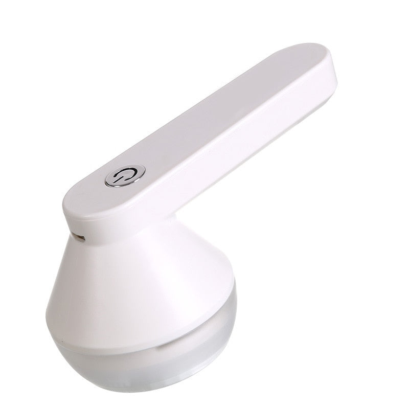 Oplaadbare FluffAway pluizenverwijderaar verbonden met USB-kabel; klaar voor gebruik op kleding en textiel.