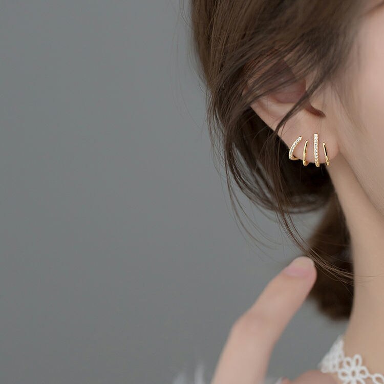 Trendy goudkleurige claw oorstekers voor dames, versierd met sprankelend strass voor een moderne look.
