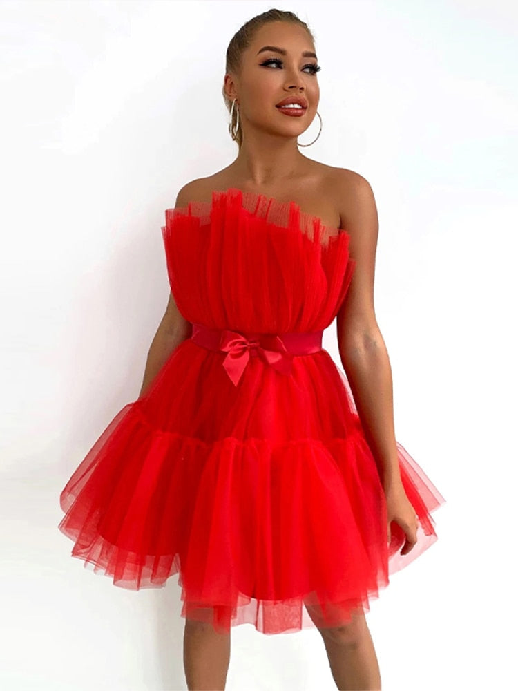 Korte roze strapless jurk, speels en elegant, ideaal voor bruiloften of tuinfeesten.