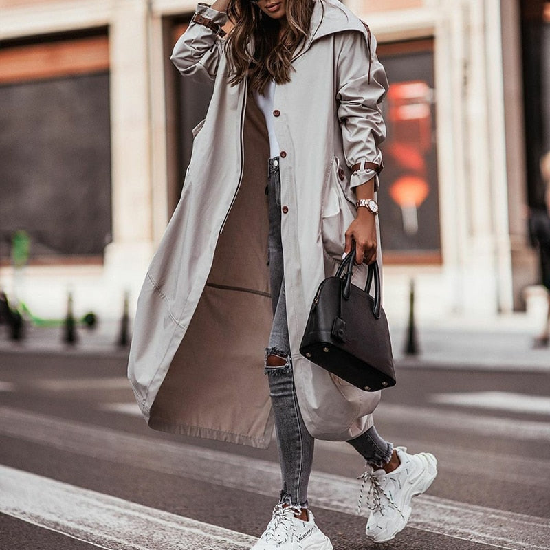 Stijlvolle grijze dames trenchcoat met lange snit en zakken, een elegante jas voor comfortabel voorjaar en najaar.