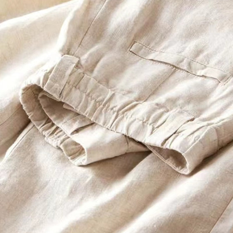Model loopt in een witte pantalon Diana met wijde pijpen, die een vloeiende en elegante beweging creëert, hoge taille broek.