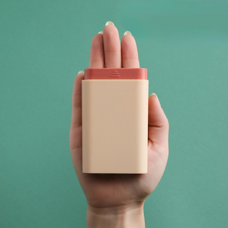 Grijs pillendoosje, een onmisbare organizer voor vitamines en medicatie tijdens het reizen.