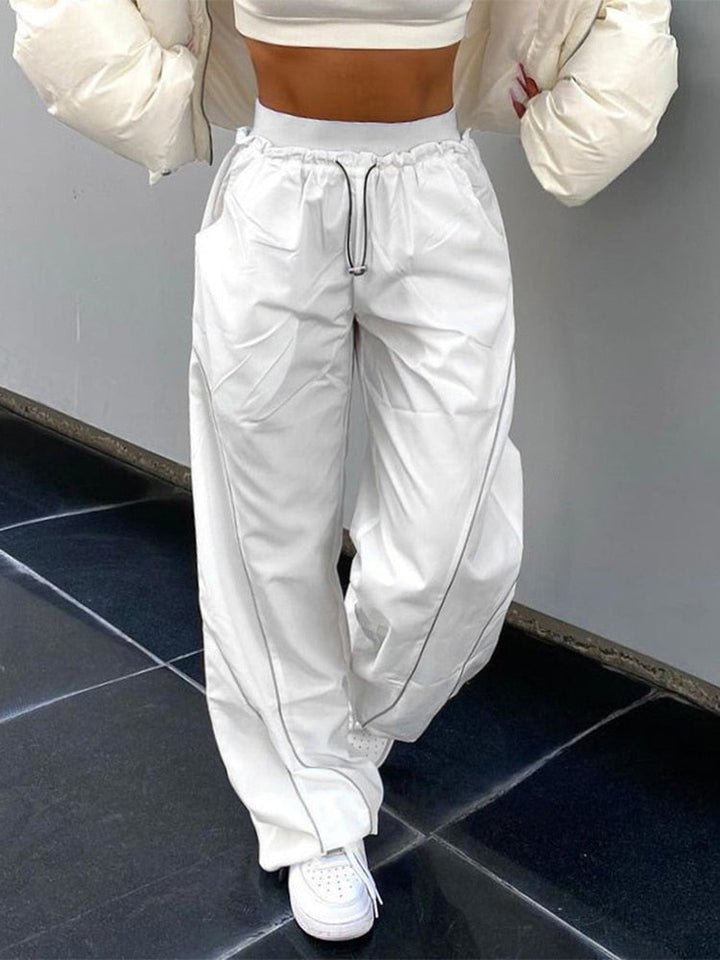 Detailopname van de stof van een zwarte dames baggy broek, comfortabel voor streetwear.