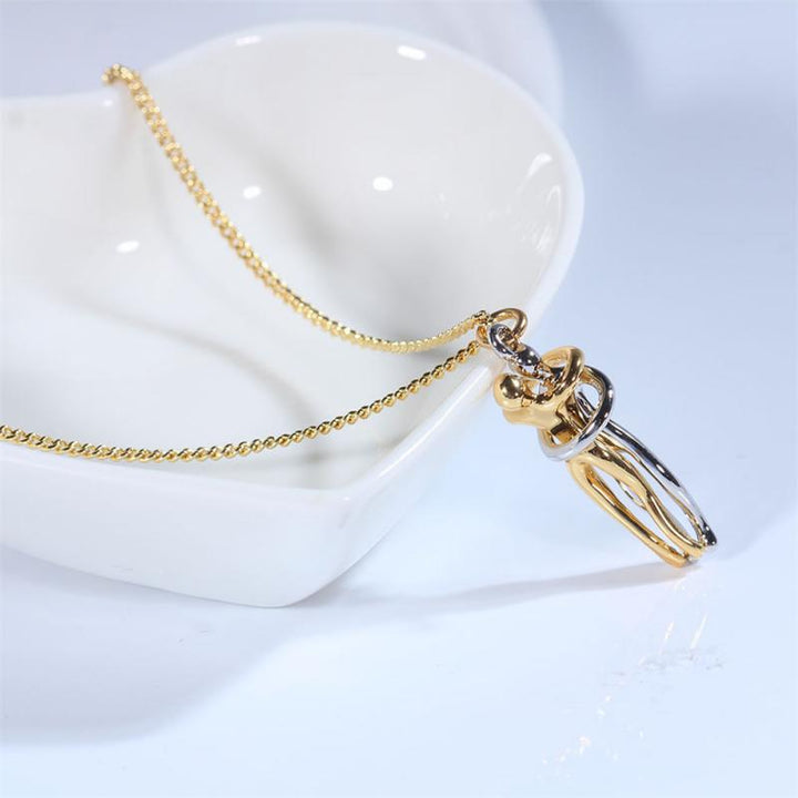 Detail van de Omhelzing hanger, een unisex symbool van liefde aan een verfijnde ketting.