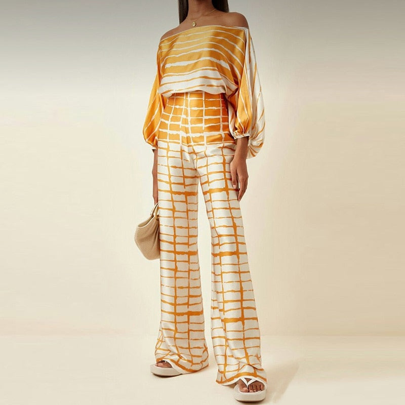 Model draagt elegante Classy Cassidy satijnen outfit; losse pasvorm, hoge taille, perfecte zomeroutfit.