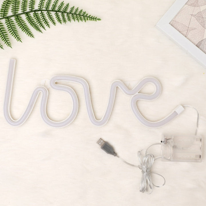 Levendige 'Love' neon verlichting met rode gloed tegen een donkere achtergrond, voor een knusse sfeer.