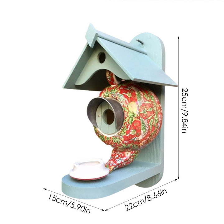 Charmant theepot vogelvoederhuisje, gemaakt van duurzaam keramiek en hars. Mooie tuinaccessoire.