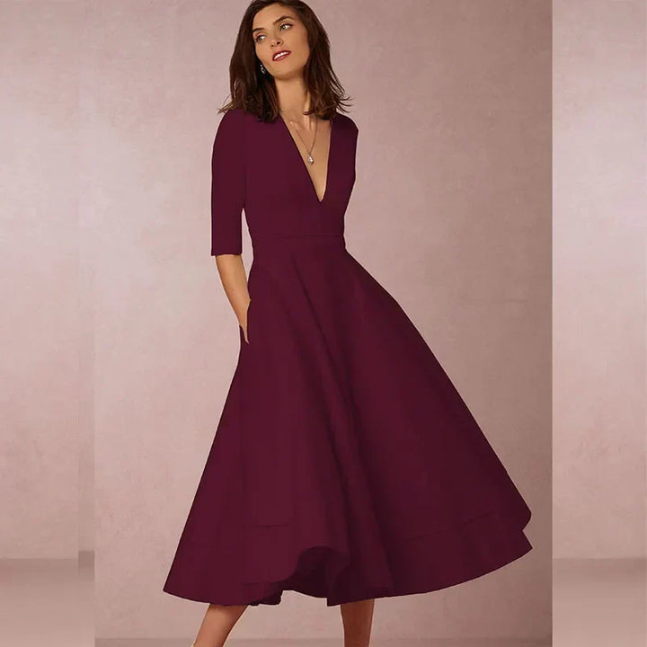 Stijlvolle zwarte A-lijn jurk voor dames, midi lengte, V-hals, driekwartmouw en volumineuze rok. Elegant.