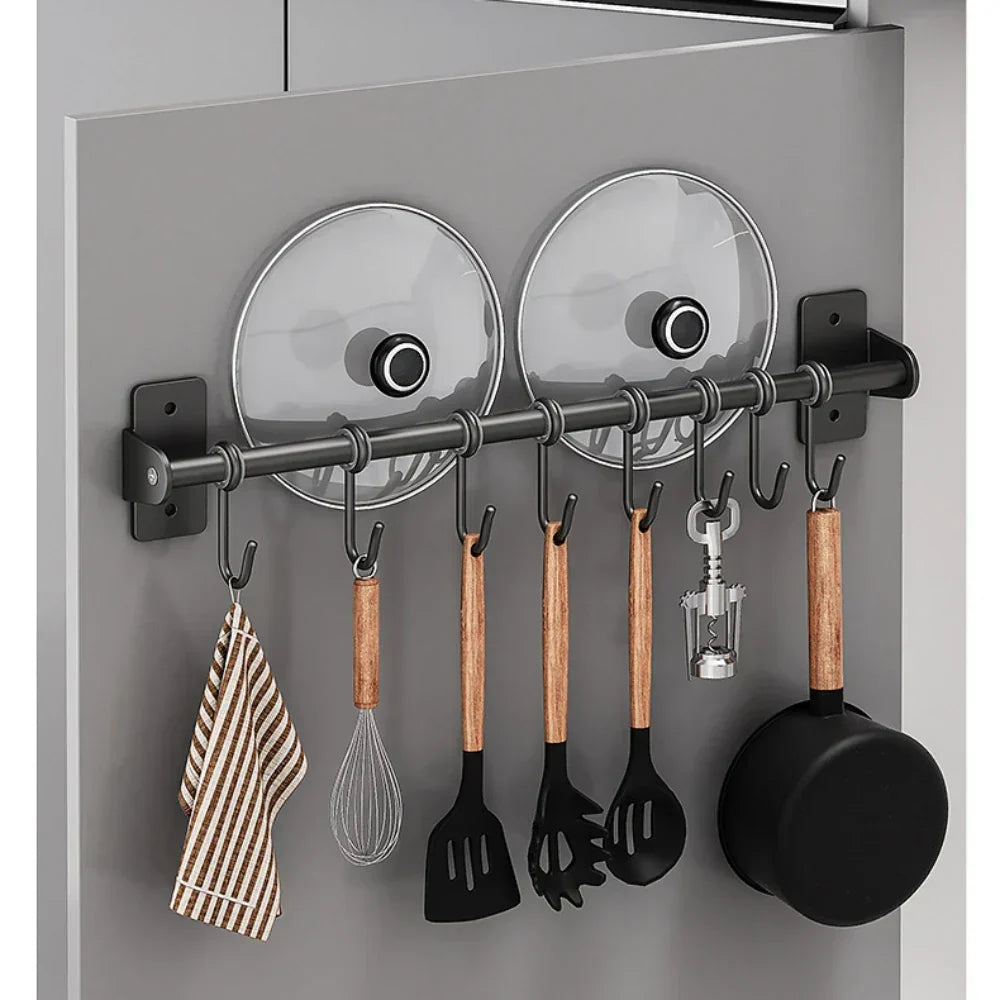 Ruimtebesparend keuken wandrek van roestvrijstaal met haken voor pannen en een houder voor deksels.