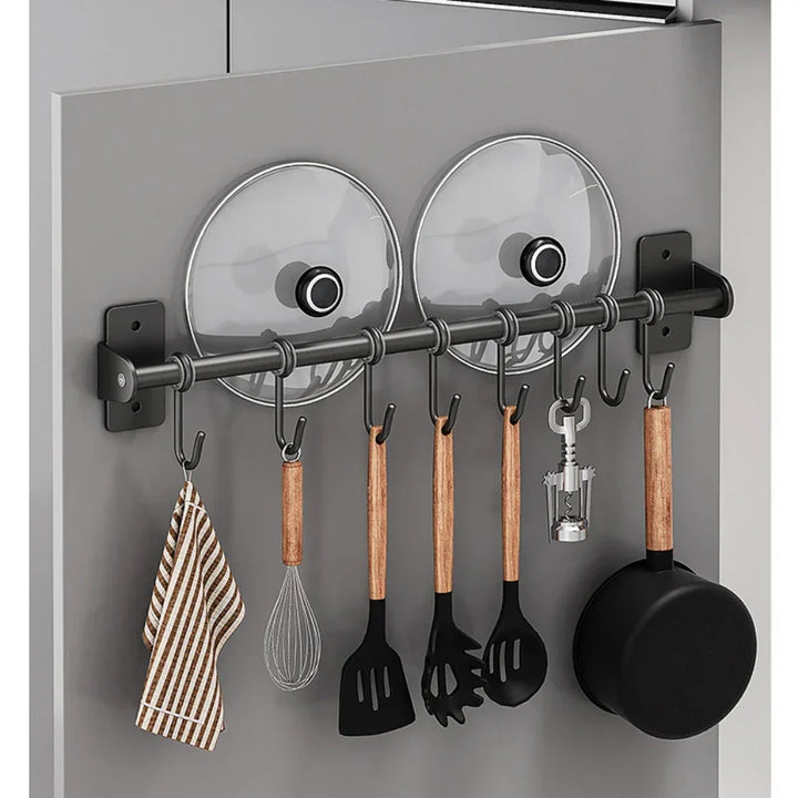 Ruimtebesparend keuken wandrek van roestvrijstaal met haken voor pannen en een houder voor deksels.
