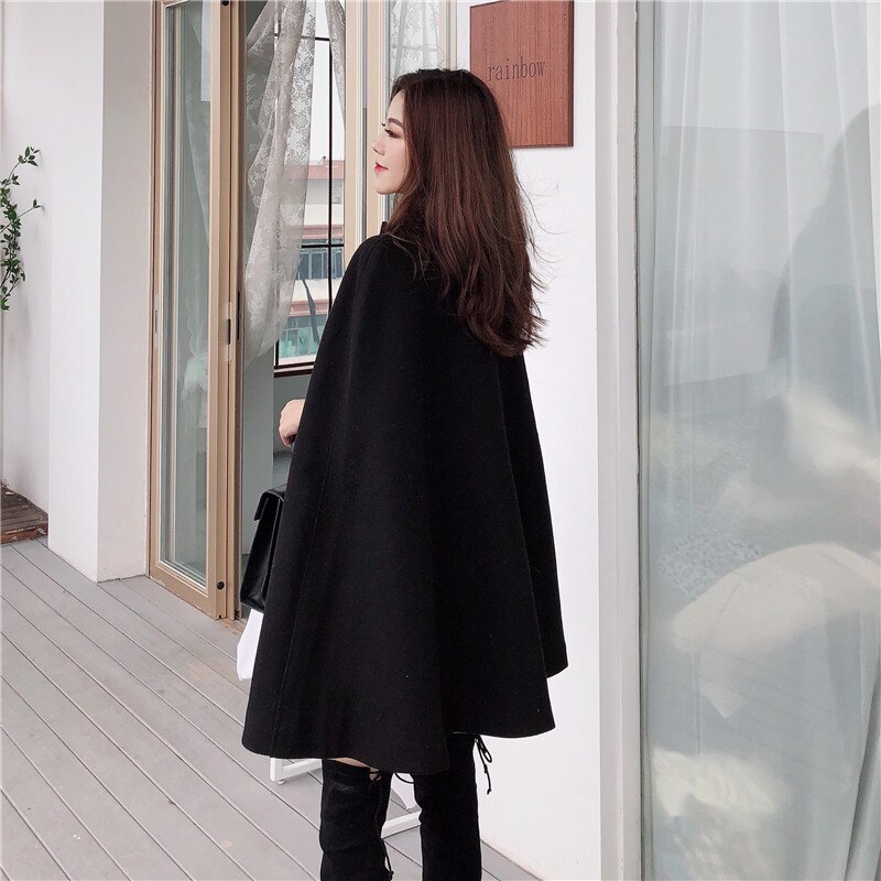 Zwarte dames cape jas met een elegant design, stijlvolle bovenkleding voor vrouwen die mode en comfort waarderen.
