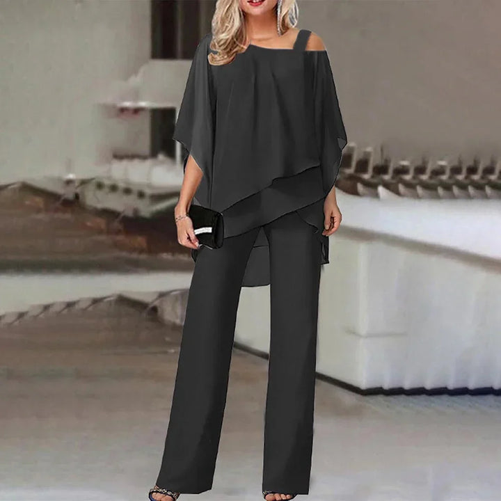 Trendy donkerblauwe dames cold-shoulder jumpsuit. Elegant design, ideaal voor een moderne en feestelijke look.