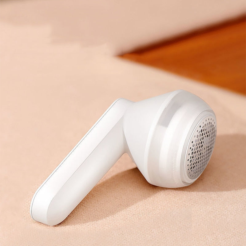 FluffAway pluizenverwijderaar met schoonmaakborstel en USB-kabel voor compleet kledingonderhoud.