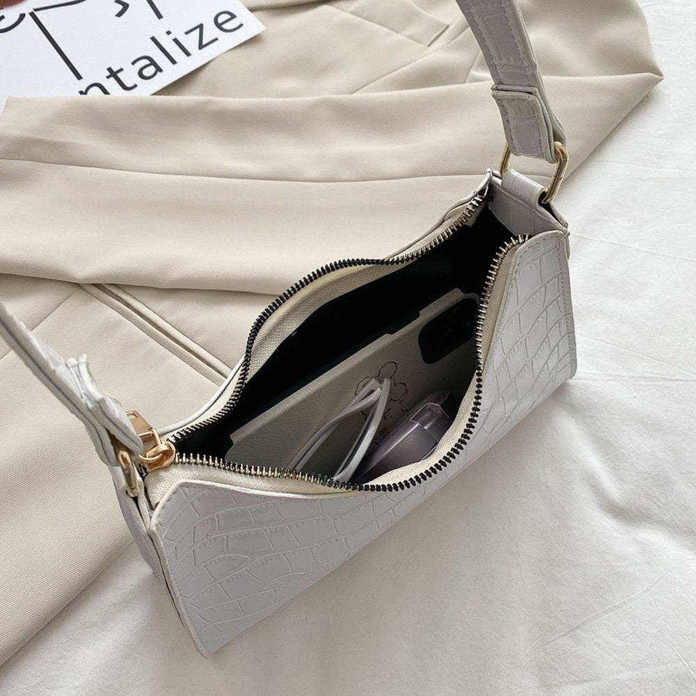 Luxe dames handtas met goudkleurige details en duurzame afwerking.
