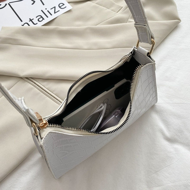 Luxe dames handtas met goudkleurige details en duurzame afwerking.
