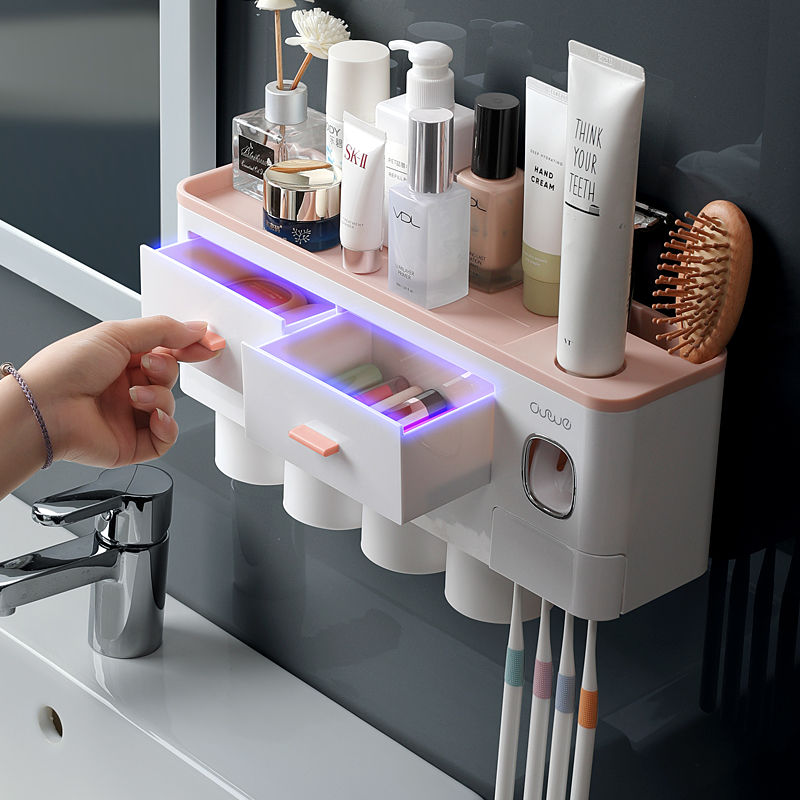 Badkamer organizer met automatische tandpastadispenser, tandenborstelhouders en opbergladen voor efficiënte badkamerorganisatie.