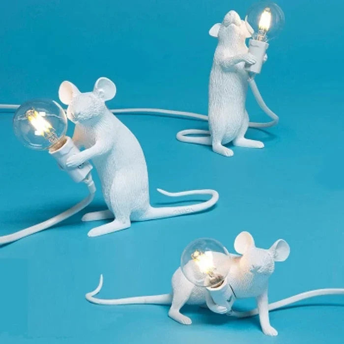 Zachte LED verlichting van de goud-witte muizenlamp. Unieke sfeervolle tafellamp, speelse dierendecoratie van hars.