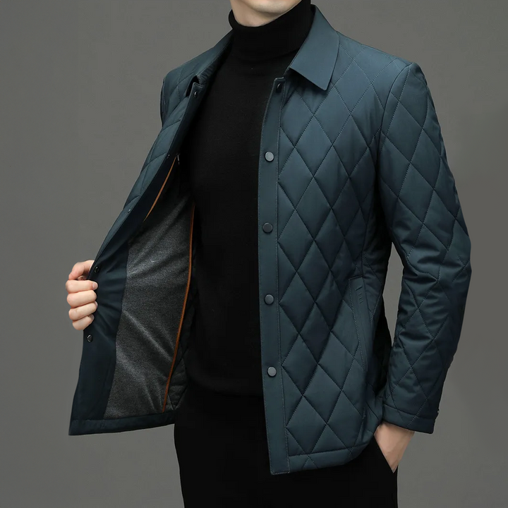 Model draagt een elegante donkerblauwe heren monogram jas, perfecte pasvorm en waterdicht voor alle weersomstandigheden.