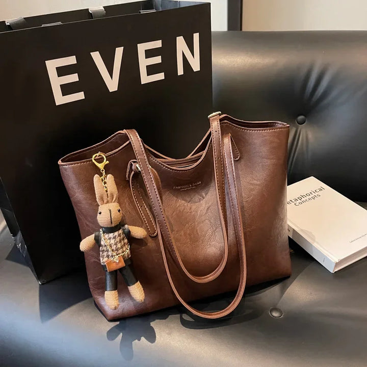 Dames accessoire: ruime vegan leren schoudertas met karakteristieke vintage uitstraling, ideaal voor werk of vrije tijd.