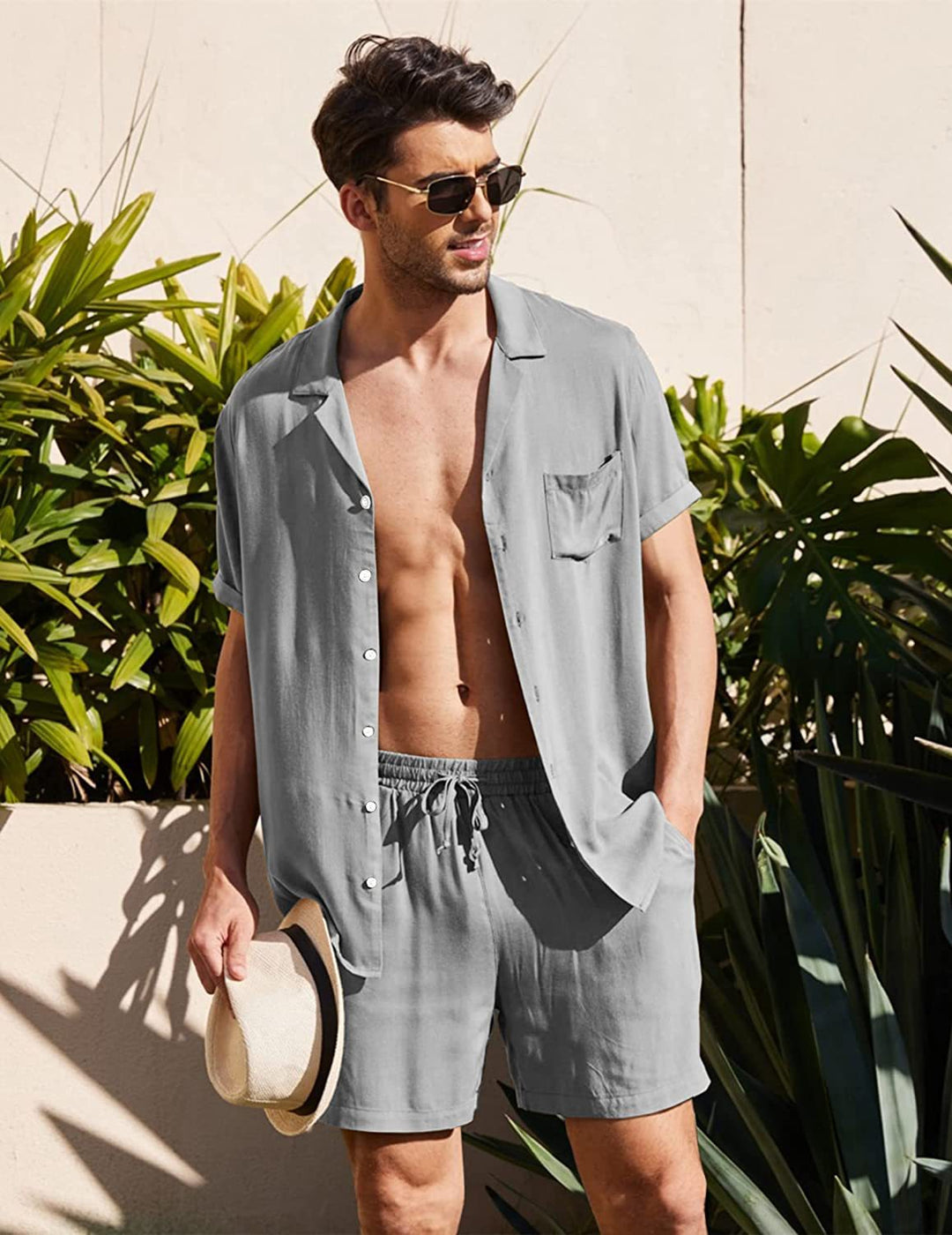 Man draagt stijlvolle luchtige katoenen blouse en short set. Perfecte casual zomerkleding voor mannen.