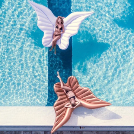 Gigantisch opblaasbed met sierlijke vleugels voor luxe relaxen op het water; ideaal voor zwembad of strand.