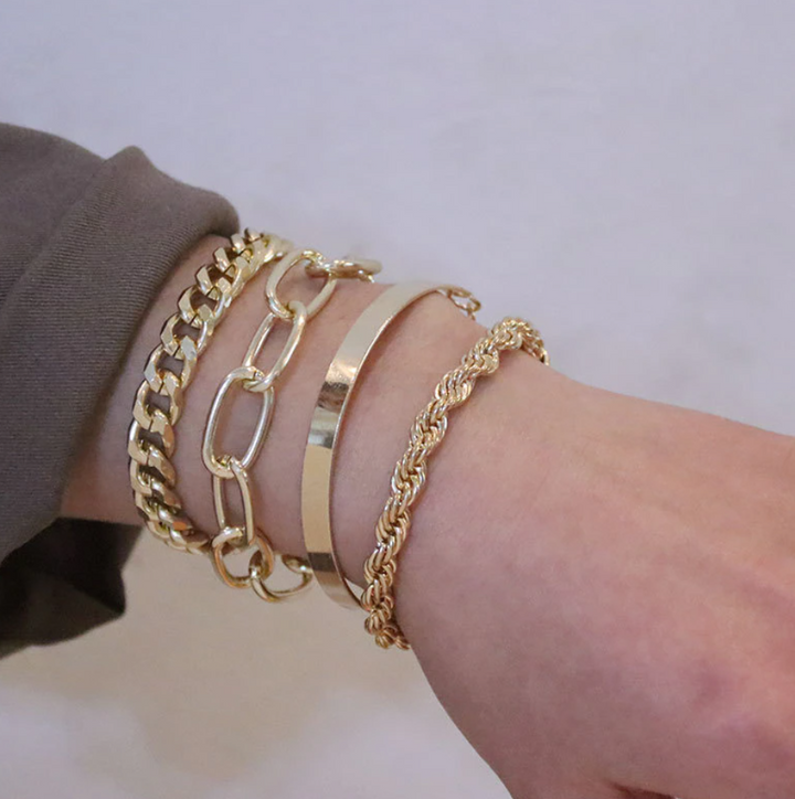 Detail van 4-delige dames armbandenset met diverse designs: vergulde schakels en verzilverde kralen van RVS.