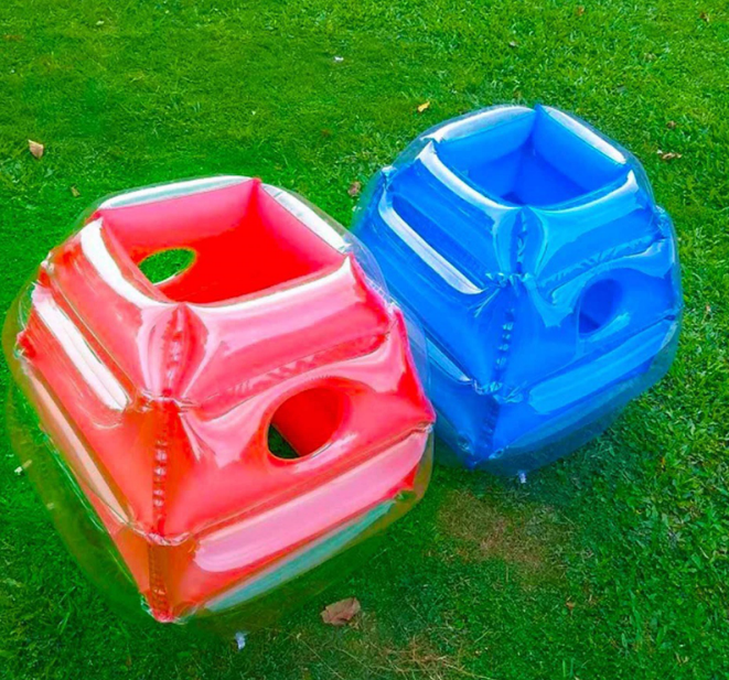 Twee kinderen spelen bubblevoetbal met opblaasbare bumperballen; veilig en hilarisch buitenspel voor plezier.
