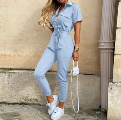 Model draagt trendy dames jumpsuit met knoopsluiting. Comfortabele en stijlvolle lente/zomer mode.