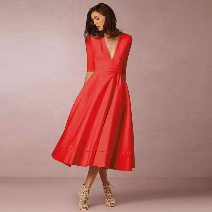 Marineblauwe A-lijn midi jurk met V-hals. Elegante damesjurk met driekwartmouw en volumineuze rok.