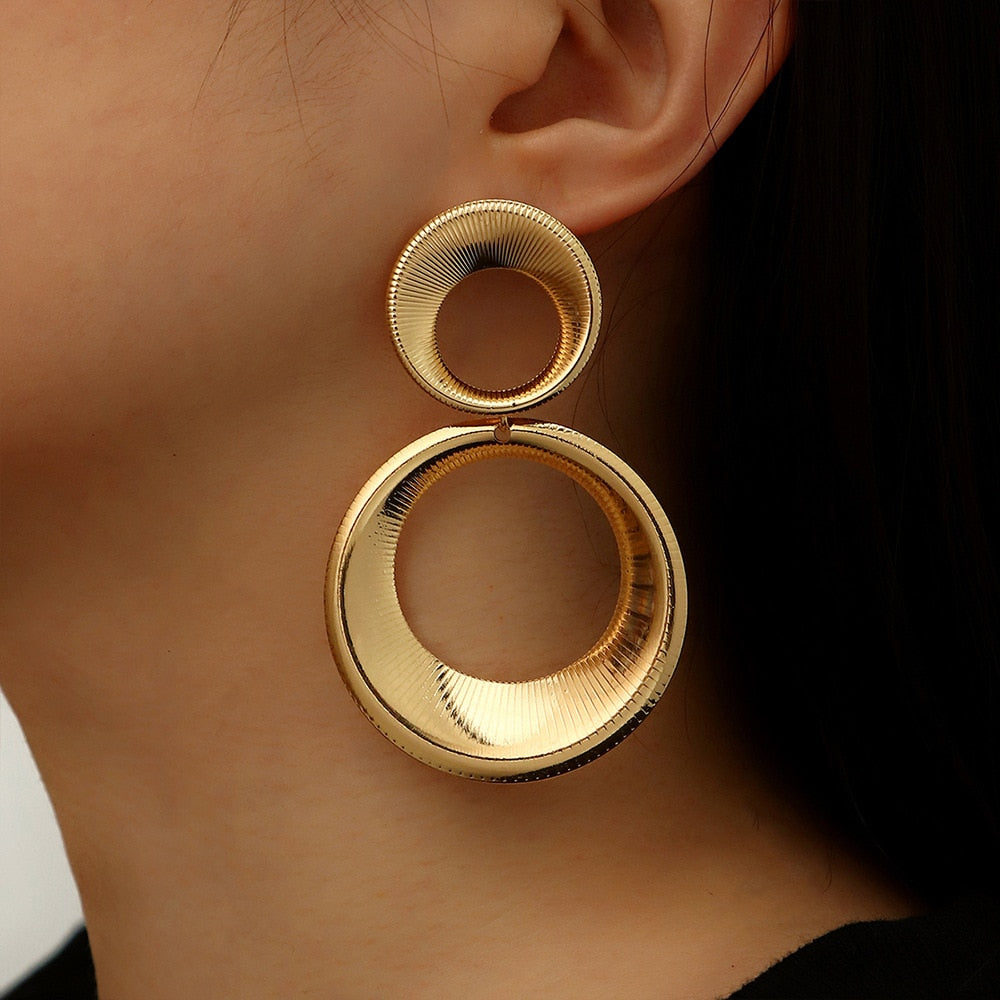 Gouden statement oorbellen dames met uniek 3D effect. Trendy en stijlvolle goudkleurige accessoires.
