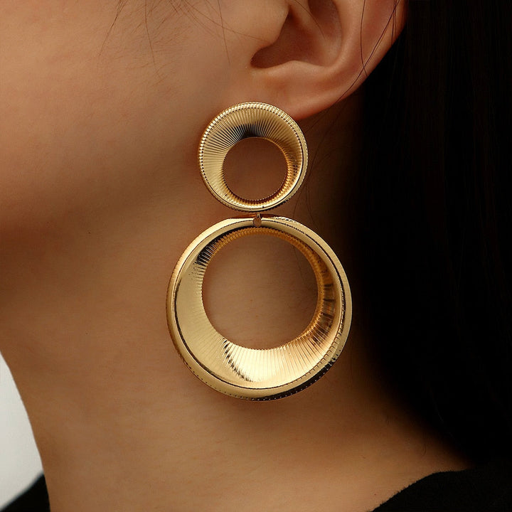 Gouden statement oorbellen dames met uniek 3D effect. Trendy en stijlvolle goudkleurige accessoires.