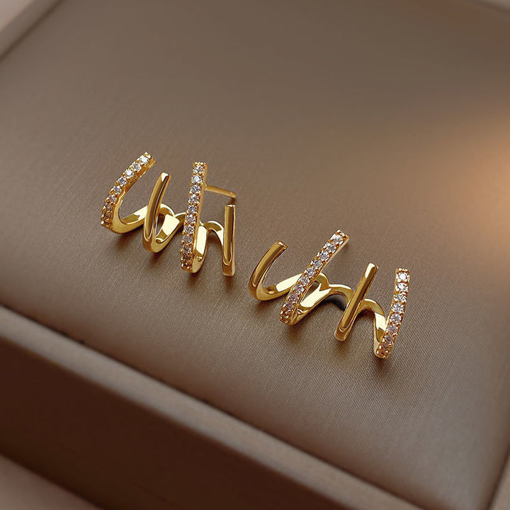 Elegante dames claw oorbellen in goud met sprankelend strass, creëren een unieke 4-in-1 piercing look.